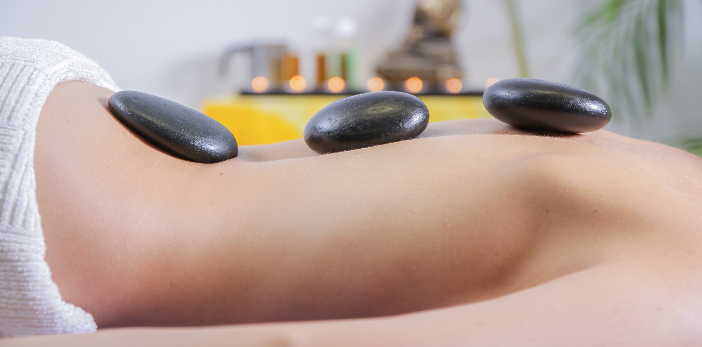 hot-stone-therapy woman's back with three hot stones placed