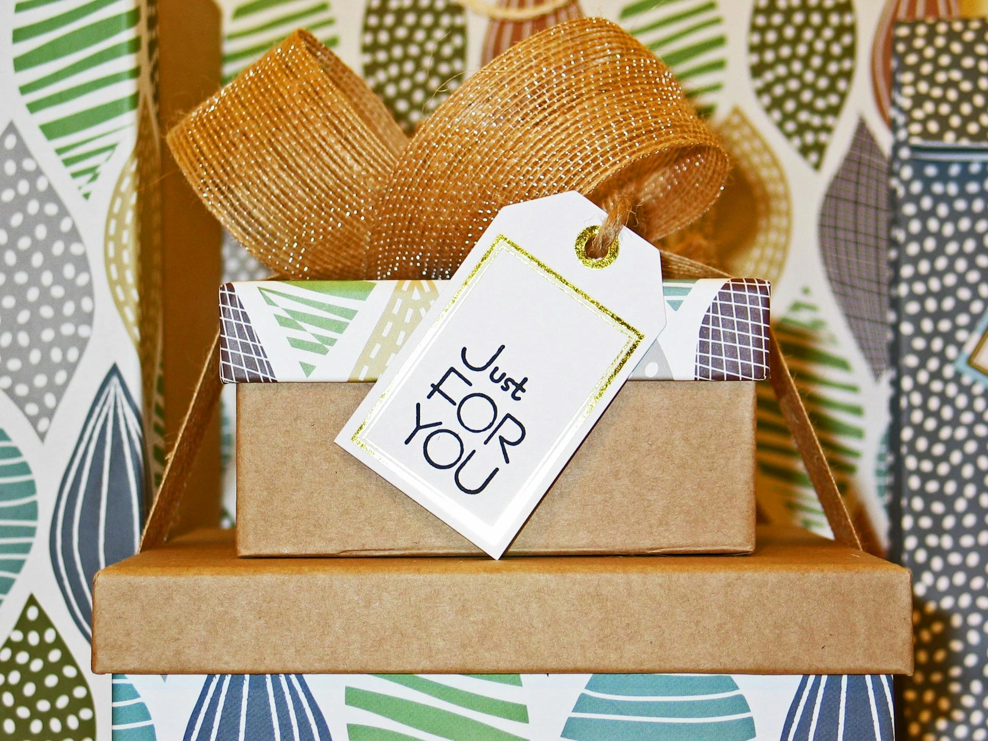 stacked wrapped gifts with a ribbon and tag that say Just For You